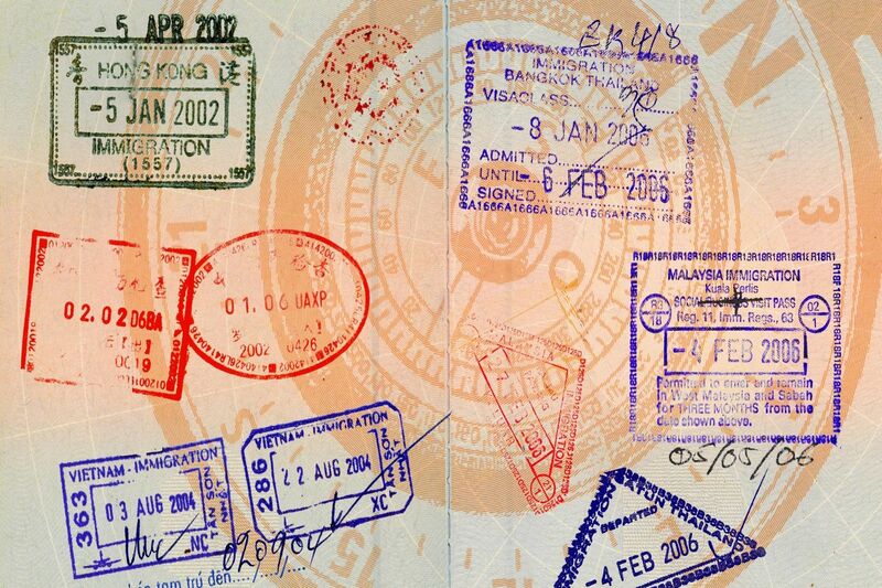 an open passport with entry stamps to countires such as Malaysia, Thailand and Hong Kong