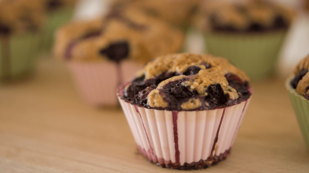 a cooked blueberry muffin with juices overflowing