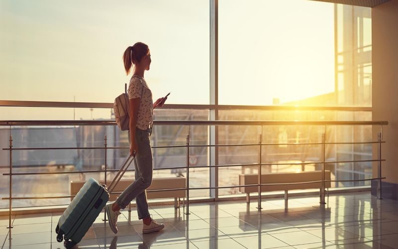 Travel Woman Walking In An Airport With A Luggage Baggage Carry-on