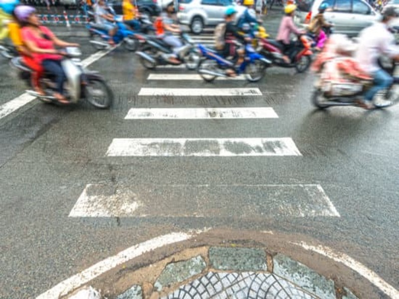 Scooters being ridden very fast of a pedestrian crossing