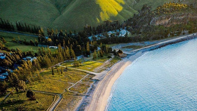 aerial view of Rapid Bay Beach and Rapid Bay Campsite. the hills and campground are covered in beautiful green grass and the ocean is a clear blue colour