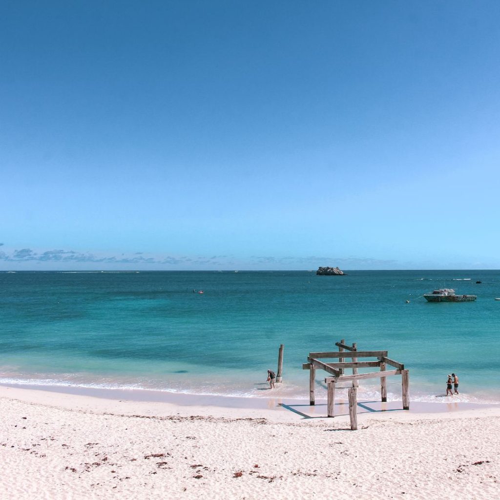 Hamelin Bay old jetty pylons to the right of the image. the white sand beach is in the foreground and the blue ocean in the background